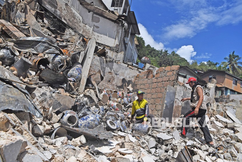 Warga mengumpulkan benda yang masih berharga dari sisa kebakaran rumah warga di Kota Jayapura, Papua, Senin (2/9/2019).