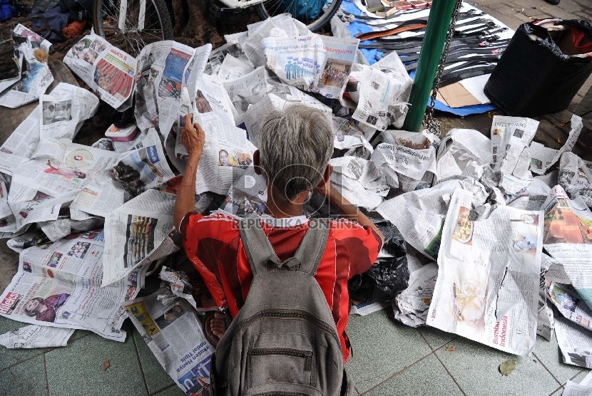 Warga mengumpulkan koran bekas di halaman masjid Cut Mutia, Jakarta, Jumat (27/2).
