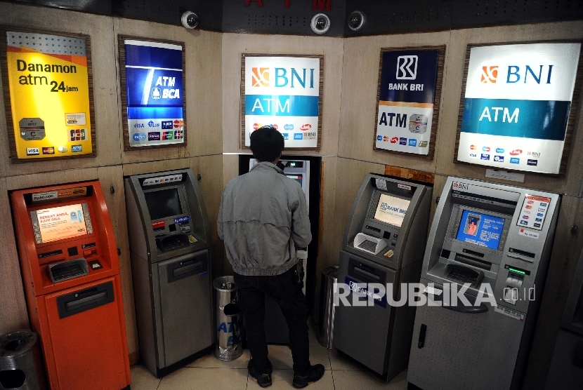  Warga mengunakan fasilitas Anjungan Tunai Mandiri (ATM) di Jakarta, Senin (18/1).
