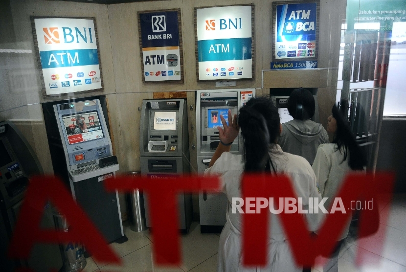 Warga mengunakan fasilitas Anjungan Tunai Mandiri (ATM) di Jakarta, Senin (18/1). 