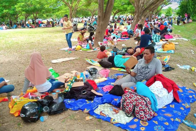 Warga mengungsi di halaman Bandara Mutiara Sis Al Jufri di Palu, Sulawesi Tengah, Sabtu (29/9).