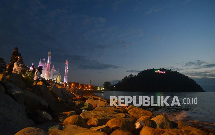 Warga menikmati senja dengan latar tagline Kota Padang yang baru dibangun di Gunung Padang, (ilustrasi).