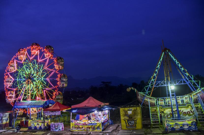 Warga menikmati wahana pasar malam di Desa Cikoneng, Kabupaten Ciamis, Jawa Barat, Kamis (9/6/2022). Wahana pasar malam yang menyajikan beragam permainan dan hiburan kini kembali bergeliat seiring meredanya kasus COVID-19 dan kelonggaran pemberlakuan pembatasan kegiatan masyarakat (PPKM). 