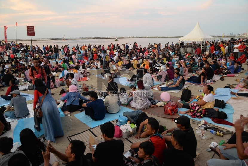   Warga menikmati wisata di pantai Ancol, Jakarta Utara, Kamis (31/12).  (Republika/Yasin Habibi)