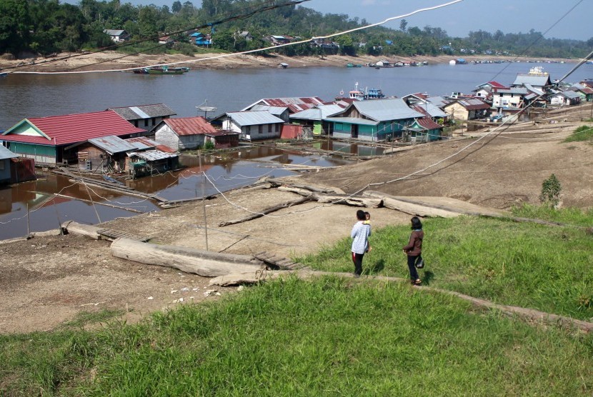 Warga meniti kayu bulat yang berfungsi sebagai jalan menuju tempat tinggalnya di rumah terapung Sungai Barito di Muara Teweh, Barito Utara, Kalimantan Tengah, Selasa (7/7). 