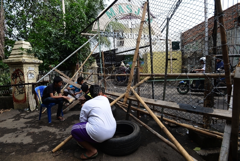  Warga menjaga blokade di Komplek Zeni Jalan Mampang Prapatan V, Jakarta Selatan, Jumat (18/12). (Republika/Raisan Al Farisi)