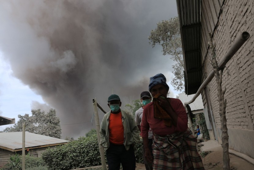 Warga menjauh dari Gunung Sinabung ketika erupsi, di Desa Sukandebi, Karo, Sumatera Utara, Selasa (24/5). (Antara/Irsan Mulyadi)