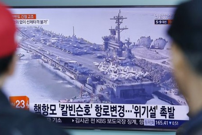 Warga menonton program berita yang menampilkan foto kapal induk AS, USS Carl Vinson di stasiun kereta Seoul, Korea Selatan, 12 April 2017. USS Carl Vinson dalam perjalanan menuju Semenanjung Korea.