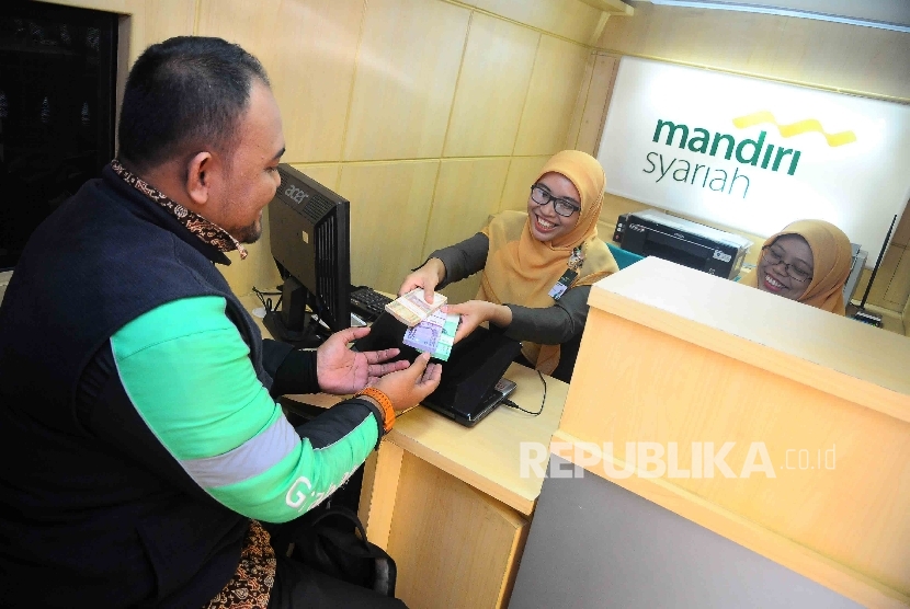 Warga menukarkan uang pecahan kecil di mobil kas kelilinga Bank Syariah Mandiri (BSM) di IRTI Monas, Jakarta, Senin (20/6).