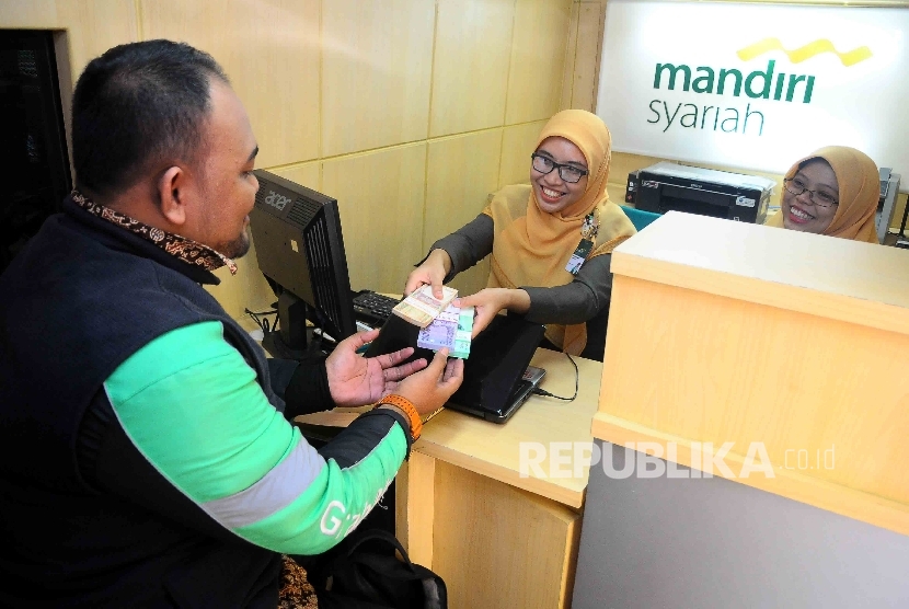 Warga menukarkan uang pecahan kecil di mobil kas kelilinga Bank Syariah Mandiri (BSM) di IRTI Monas, Jakarta, Senin (20/6).