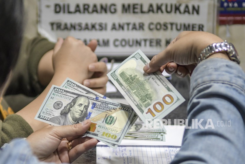 Warga menukarkan mata uang dolar AS di sebuah gerai money changer, Jakarta, Jumat (28/2/2020).(Antara/Galih Pradipta)