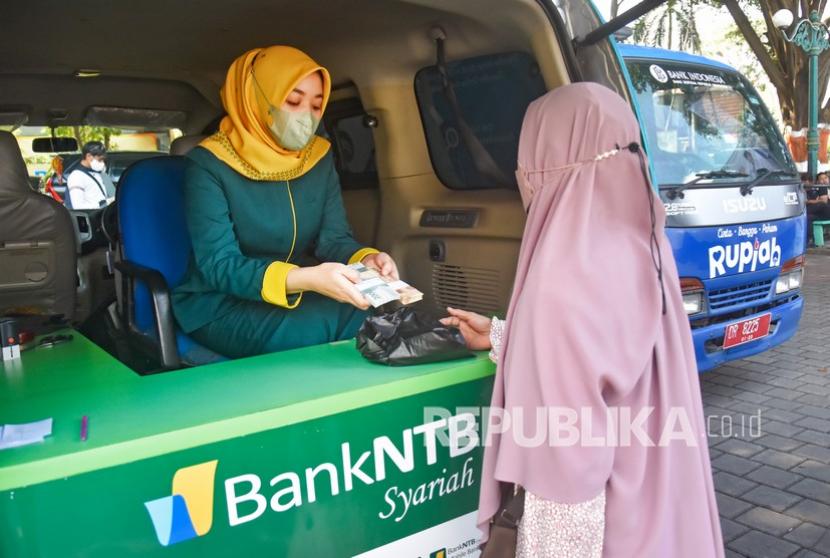 Warga menukarkan uang pecahan kecil di mobil pelayanan keliling Bank Syariah NTB (ilustrasi). PT Bank Negara Indonesia (Persero)Tbk (BNI) dan PT Bank Nusa Tenggara Barat (NTB) Syariah menandatangani nota kesepahaman untuk mengembangkan dan memperkuat layanan perbankan daerah.