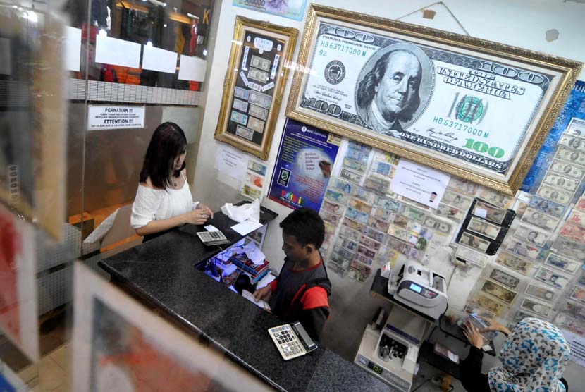  Warga menukarkan valas di jasa penukaran uang, Jakarta, Senin (19/5). 