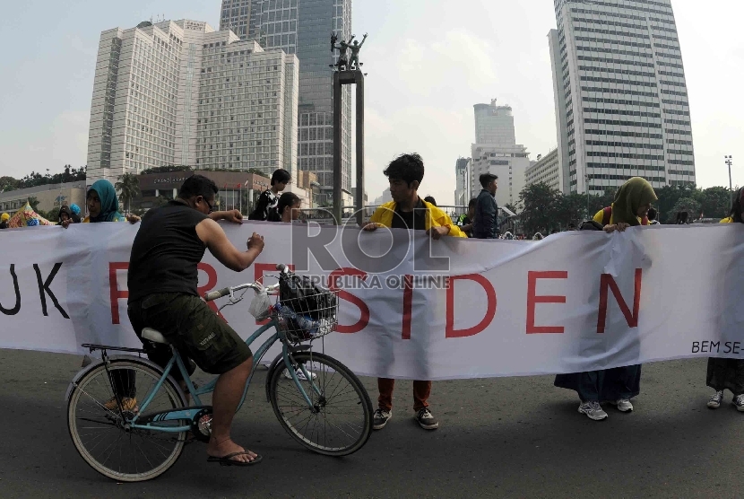Warga menuliskan saran dan kritiknya pada spanduk surat terbuka untuk Presiden yang diadakan oleh mahasiswa BEM UI di Bundaran HI, Jakarta, Ahad (17/5).  (Republika/Agung Supriyanto)