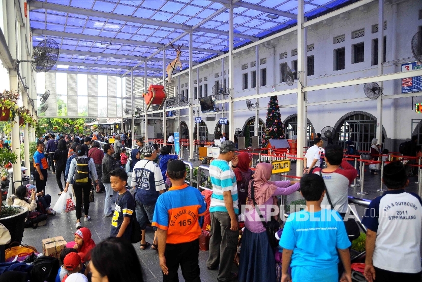 Warga menunggu kedatangan  Kereta Api di Stasuin Senen, Jakarta Pusat, Senin (26/12).