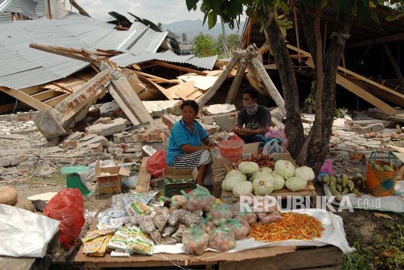 Warga menunggu pembeli di antara reruntuhan bangunan akibat gempa di Petobo, Palu, Sulawesi Tengah, Kamis (4/10).