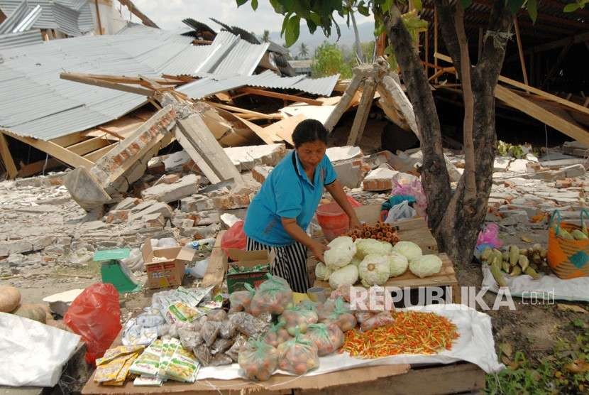 Warga menunggu pembeli di antara reruntuhan bangunan akibat gempa di Petobo, Palu, Sulawesi Tengah, Kamis (4/10). 