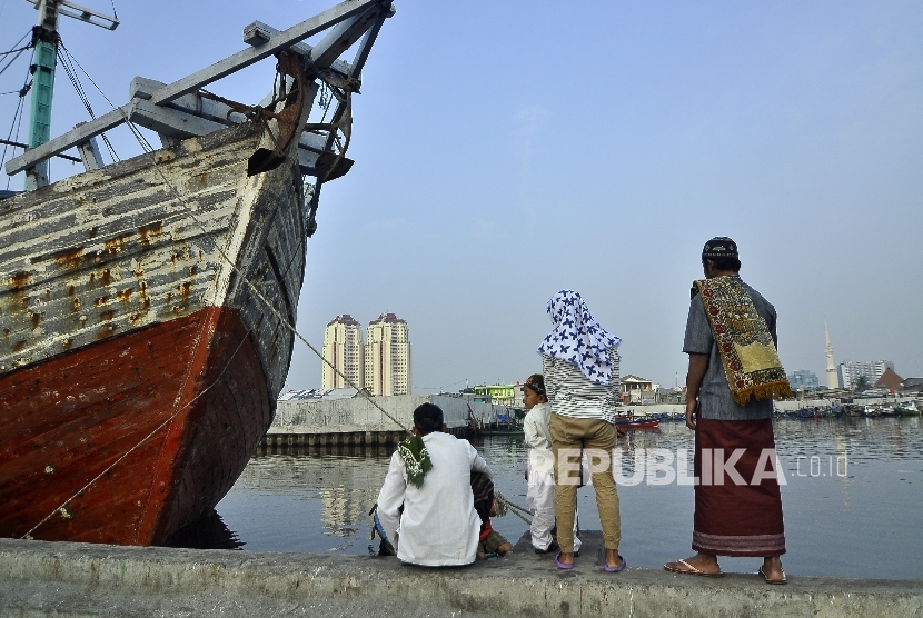   Warga menunggu perahu getek seusai melaksanakan Shalat Idul Adha di Pelabuhan Sunda Kelapa, Jakarta Utara, Jumat (1/9).