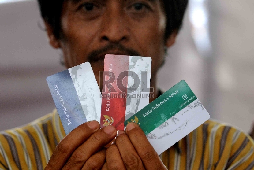 Warga menunjukan Kartu Indonesia Sehat (KIS), Kartu Keluarga Sejahtera (KKS) dan Kartu Indonesia Pintar (KIP) saat pembagian tiga jenis kartu sakti itu di Kampung Melayu, Jakarta Timur, Rabu (13/5). (Republika/Agung Supriyanto)