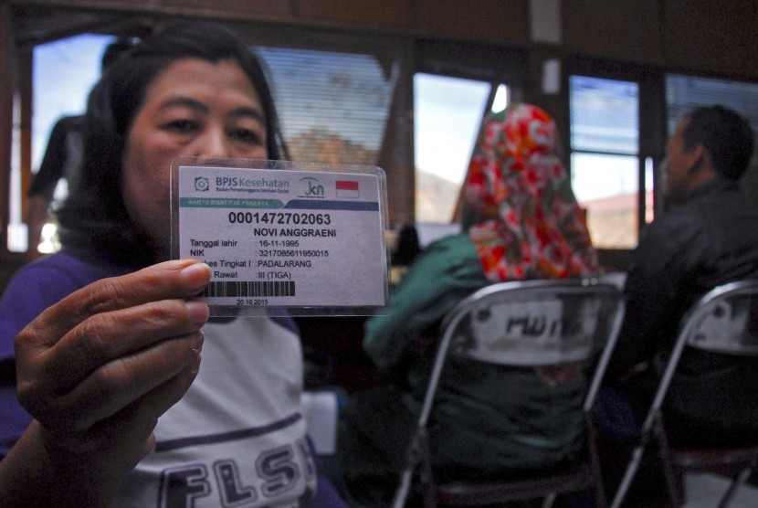 Warga menunjukan sebuah kartu peserta Badan Penyelenggara Jaminan Sosial (BPJS) Kesehatan palsu atau yang tidak terdaftar secara resmi saat melakukan laporan dan pemeriksaan di Polres Cimahi, Jawa Barat, Senin (25/7).