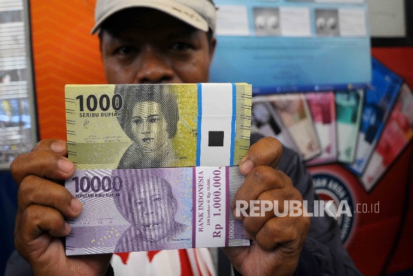  Warga menunjukan uang rupiah baru (ilustrasi) 
