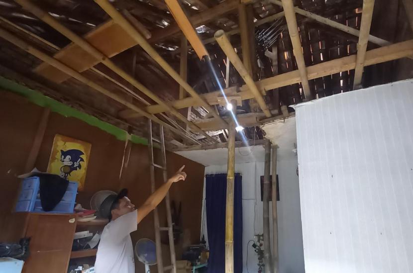 Warga menunjukkan bagian rumah di Kelurahan Tuguraja, Kecamatan Cihideung, Kota Tasikmalaya, yang mengalami akibat gempa bumi yang berpusat di Kabupaten Garut, Sabtu (3/12/2022). Per Ahad (3/12/2022), rumah itu sementara dikosongkan pemiliknya.