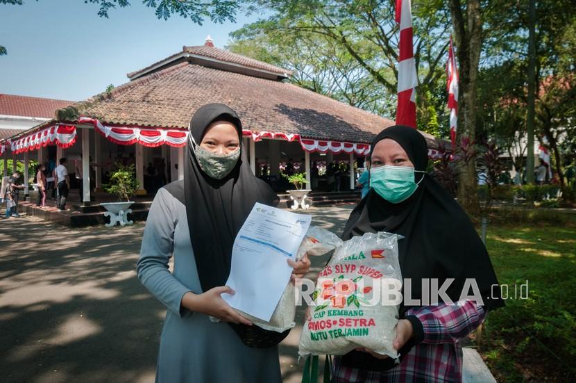 Warga menunjukkan beras bantuan saat mengikuti vaksinasi COVID-19 di Pendopo Kabupaten Lebak, Banten, Senin (2/8/2021). Pemerintah Kaputen Lebak menggelar vaksinasi gratis beras guna meringankan masyarakat yang terdampak pandemi COVID-19.
