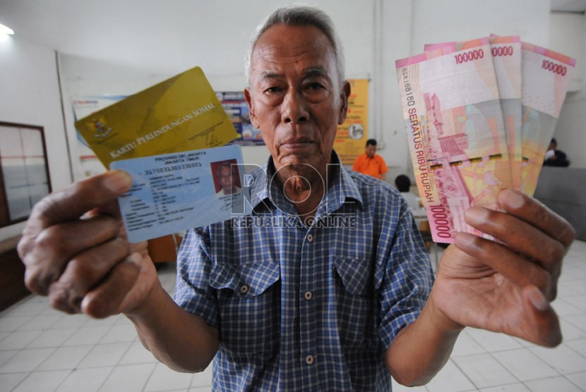  Warga menunjukkan kartu perlindungan sosial dan uang Bantuan Langsung Sementara Masyarakat (BLSM) di Jakarta. Sebanyak 750 KPS di Tangerang gagal antar karena alamat warga sudah berganti. (Republika/Aditya Pradana Putra)
