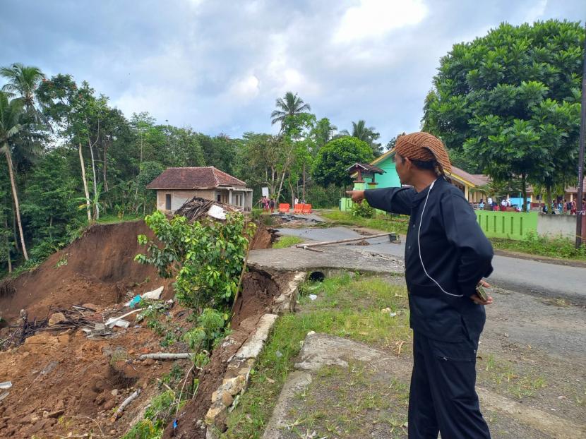 Warga menunjukkan lokasi kejadian bencana longsor yang berdampak terhadap ruas jalan kabupaten di wilayah Desa Girikencana, Kecamatan Parungponteng, Kabupaten Tasikmalaya, Rabu (2/11/2022). 
