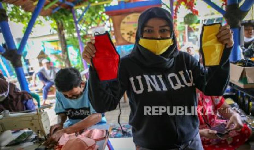 Warga menunjukkan masker berbahan kain 