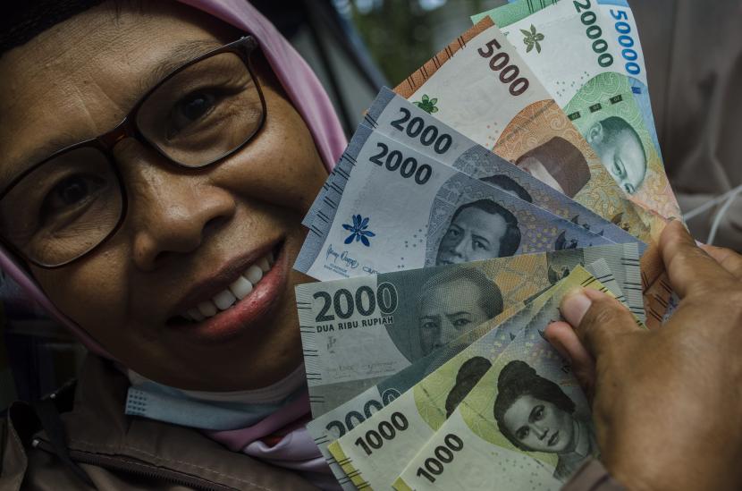Warga menunjukkan pecahan uang rupiah kertas terbaru. Bank Indonesia (BI) menyosialisasikan uang rupiah baru ke nelayan Muara A
