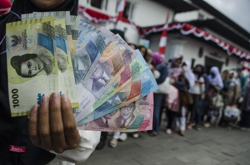 Warga menunjukkan pecahan uang rupiah kertas terbaru. (ilustrasi)
