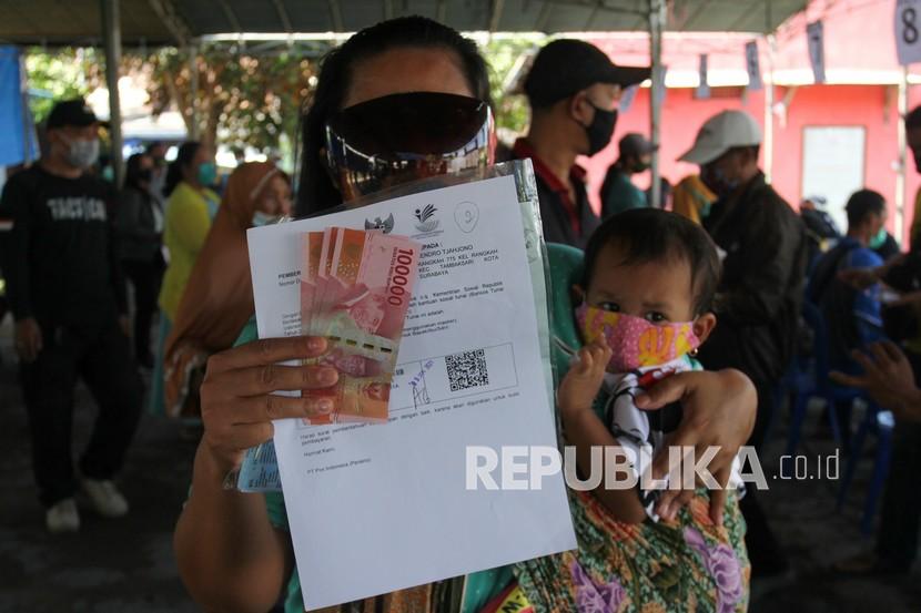 Warga menunjukkan uang Bantuan Sosial Tunai (BST) yang diperolehnya. (ILustrasi)