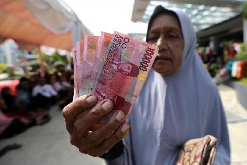 Warga menunjukkan uang zakat konsumtif yang diterimanya dari lembaga penyaluran zakat Baitul Mal  (ilustrasi)