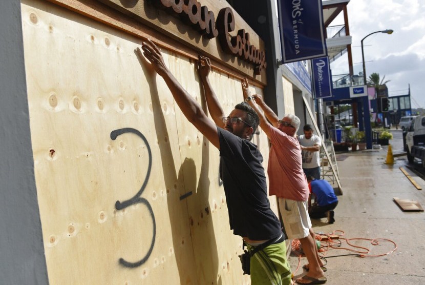 Warga menutup sebuah toko dengan papan kayu sebagai persiapan diterjang Badai Humberto di Hamilton, Bermuda, Rabu (18/9).