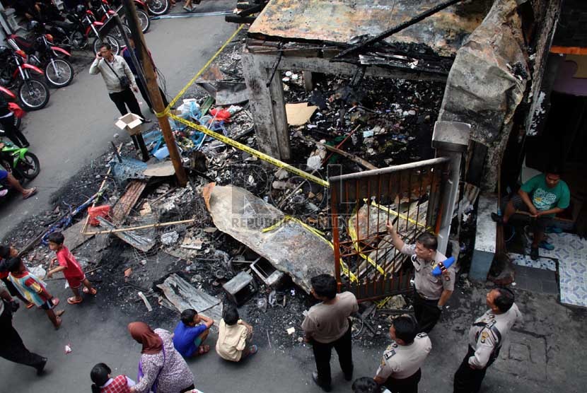   Warga menyaksikan bangunan yang terbakar akibat tawuran antarwarga di Johar Baru, Jakarta Pusat, Senin (18/11). (Republika/Yasin Habibi)
