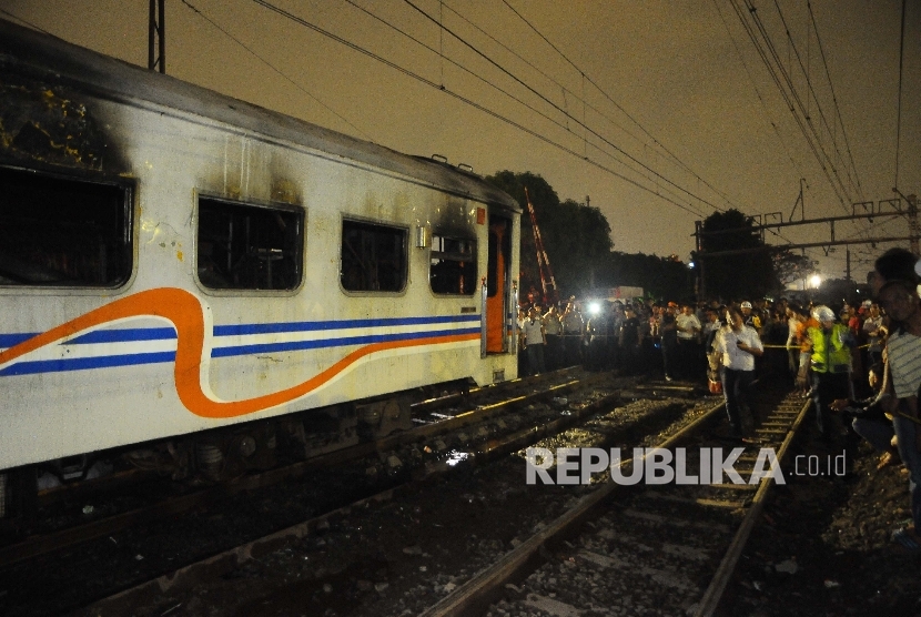 Warga menyaksikan gerbong kereta yang terbakar saat kecelakaan kereta api di perlintasan kereta jalan Kembang Pacar, Kramat, Senen, Jakarta Pusat, Selasa (13/6). 