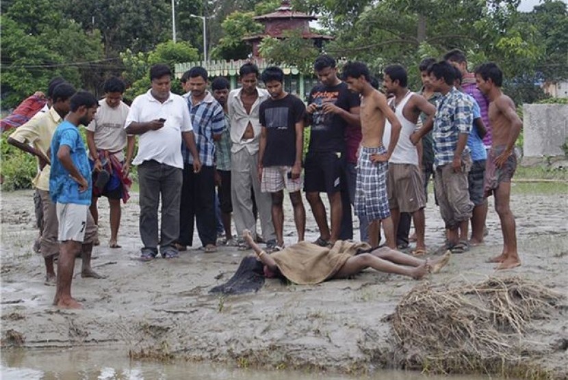 Warga menyaksikan jenazah korban kerusuhan etnis di dekat Kota Kokorajhar, negara bagian Assam, India, pada Sabtu (21/7).