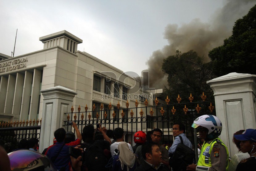   Warga menyaksikan kepulan asap tebal yang melanda Gedung Sekretariat Negara di Komplek Istana Negara, Jakarta, Kamis (21/3) sore.  (Republika/Adhi Wicaksono)