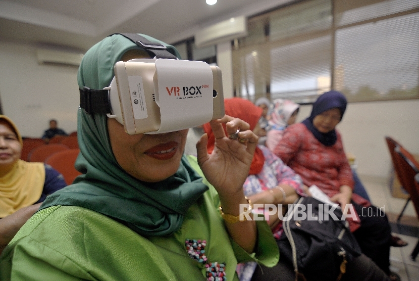 Warga menyaksikan langsung (live streaming) pelantikan Gubernur dan Wakil Gubernur DKI Jakarta Anies Baswedan dan Sandiaga Uno menggunakan teknologi kacamata virtual reality (VR) di Kelurahan Menteng Dalam, Jakarta, Senin (16/10). 