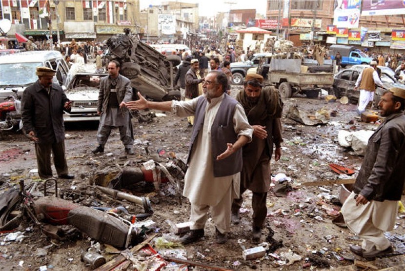 Warga menyaksikan lokasi yang hancur akibat serangan bom di Quetta, Balauchistan, Pakistan.