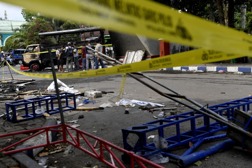 Warga menyaksikan mobil polisi yang terbakar akibat kericuhan usai pertandingan BRI Liga 1 antara Arema melawan Persebaya di Stadion Kanjuruhan, Malang, Jawa Timur, Ahad (2/10/2022). Sedikitnya 129 orang dilaporkan meninggal dunia dan 13 mobil rusak akibat kerusuhan tersebut. 