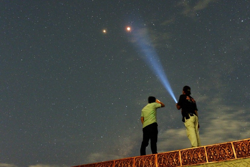 Warga menyaksikan pemandangan planet Mars berdampingan dengan gerhana bulan total terlihat di Kota Padang, Sumatera Barat, Sabtu (28/7) dini hari.