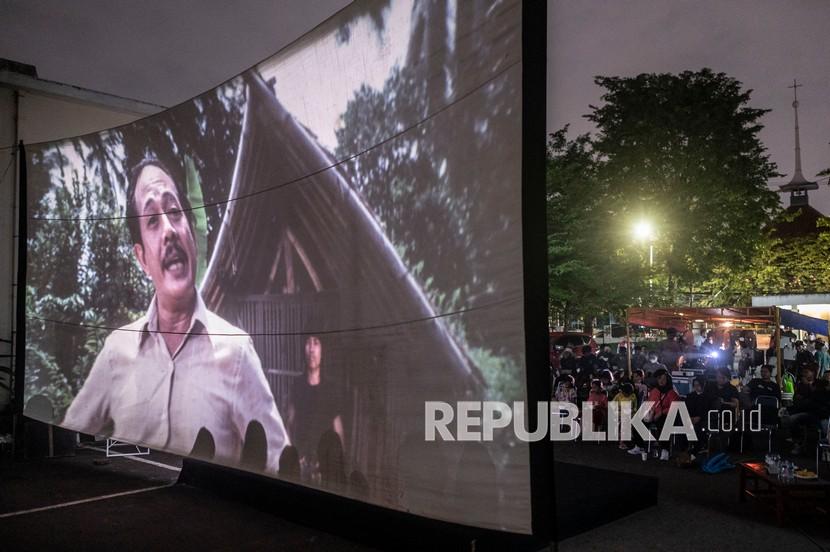 Warga menyaksikan pemutaran film Si Doel Anak Betawi karya Sjuman Djaya di halaman Perusahaan Umum Produksi Film Negara (Perum PFN), Jakarta, Kamis (31/3/2022). Perum PFN mengadakan kegiatan bioskop rakyat dalam rangka memperingati Hari Film Nasional 2022.