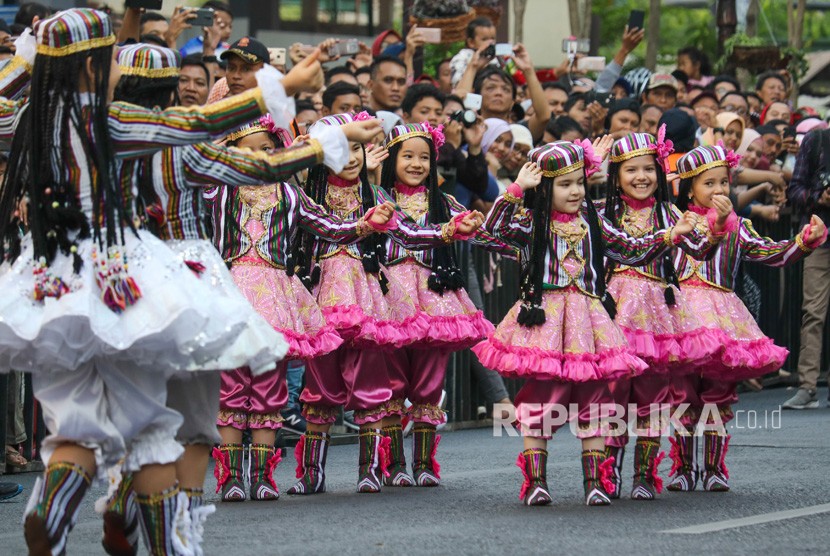 Warga menyaksikan penampilan peserta dari negara Uzbekistan pada parade lintas budaya di Jalan Tunjungan Surabaya, Jawa Timur, Ahad (15/7). 
