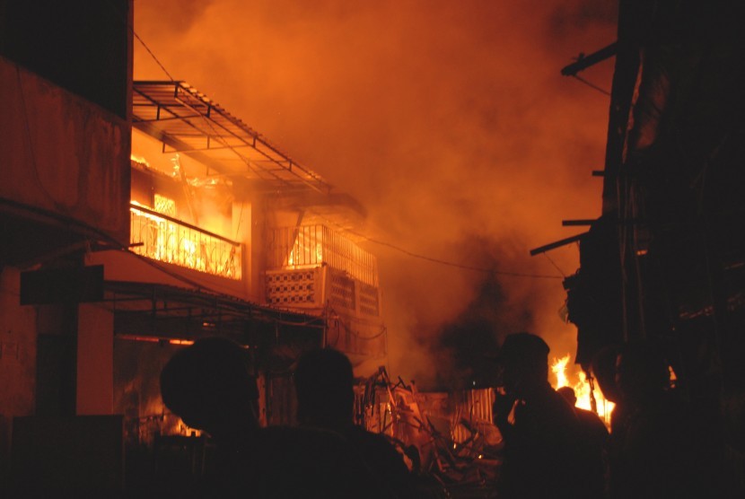 Warga menyaksikan pertokoan yang terbakar di Komplek Pasar Pelita, Kota Sukabumi, Jawa Barat, Jumat (13/5). 