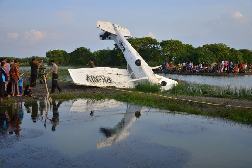 Warga menyaksikan pesawat yang mengalami kecelakaan di area Tambak Nggojoyo, Desa Wedung, Demak, Jawa Tengah, Senin (20/6). Pesawat terbang latih jenis CESNA 172 PK-NIV milik sekolah penerbangan PT Nusa Fliying Internasional (NFI) tersebut mengalami kecela