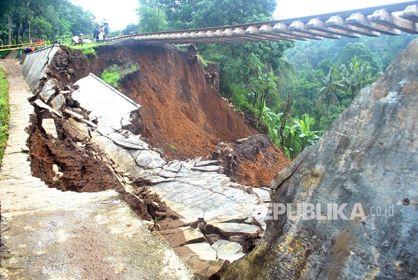 Warga menyaksikan proses evakuasi korban longsor di dekat rel KRD Bogor-Sukabumi sepanjang 40 meter yang menggantung akibat pondasi longsor di Desa Warung Menteng, Kecamatan Cijeruk, Kabupaten Bogor, Jawa Barat, Selasa (6/2).