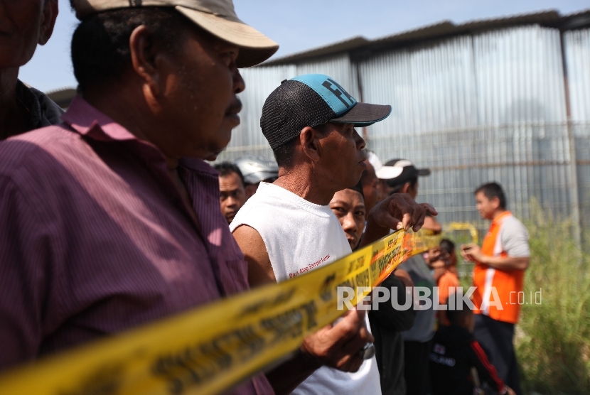 Warga menyaksikan saat petugas kepolisian melakukan olah TKP di lokasi pasca ledakan di pabrik produksi kembang api, Jalan Salembaran, Desa Belimbing, Kecamatan Kosambi Kabupaten Tangerang, Banten, Jumat (27/10).