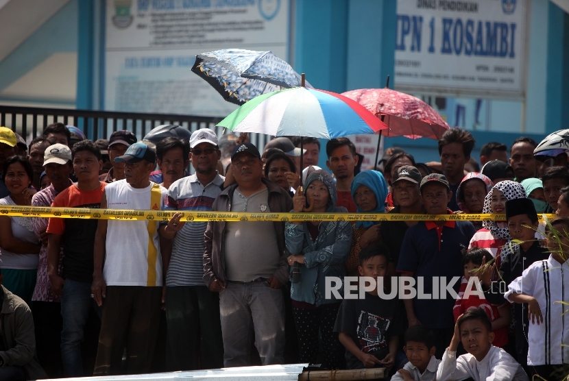 Warga menyaksikan saat petugas kepolisian melakukan olah TKP di lokasi pasca ledakan di pabrik produksi kembang api, Jalan Salembaran, Desa Belimbing, Kecamatan Kosambi Kabupaten Tangerang, Banten, Jumat (27/10).